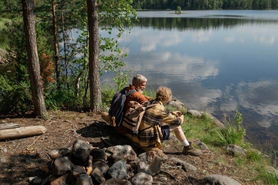 Two tourist sitting by a lake