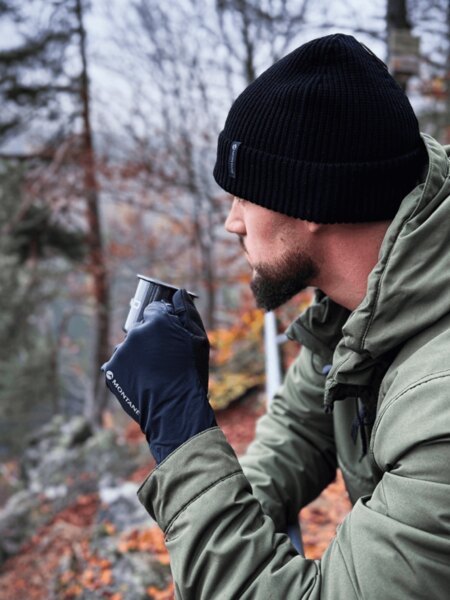 A short outdoor break in the rain, where a warm beverage helps maintain body heat, energy levels, and mental resilience in cold, wet conditions. Photo: Rigad