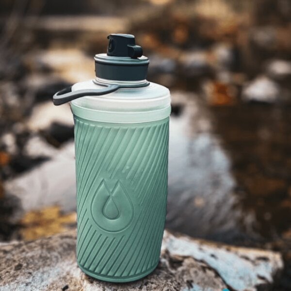 Hydrapak collapsible bottle and water filter used at a natural source. Outdoor hydration equipment. Photo: Rigad