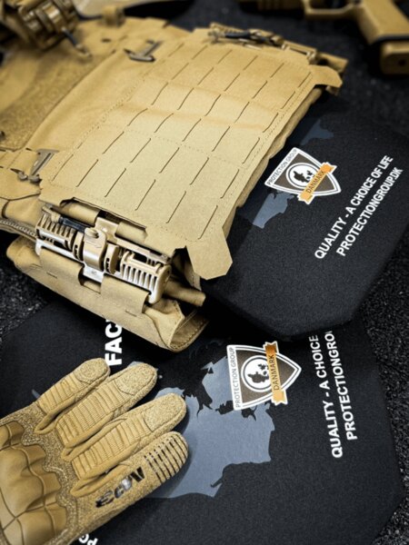 Plate carrier with inserted ballistic plates, laser-cut MOLLE, and quick-release buckles; tactical gloves (PGD) in the foreground.