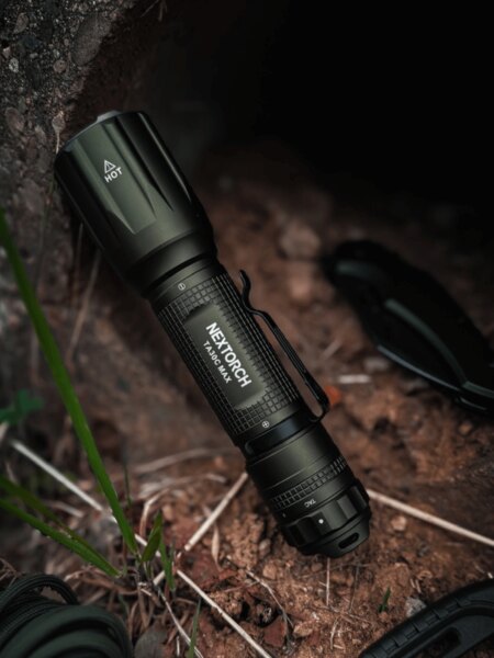 NexTorch® TA30 tactical flashlight placed on the ground in an outdoor environment. Photo: Rigad