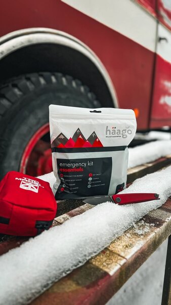 Emergency winter set Haago with thermal foil and hand warmers placed in the snow in front of the vehicle – practical car equipment for the winter season 2025/26. Photo: Rigad