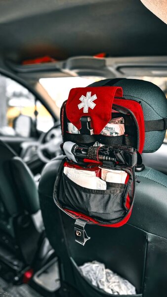 Helikon-Tex expanded first aid kit attached to the back of a car seat – organized and quickly accessible equipment for winter emergency situations. Photo: Rigad