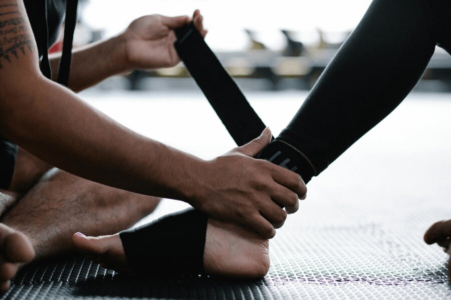 Wrapping the ankle in a stable injury – applying compression with an elastic bandage. Photo: https://www.pexels.com/photo/person-sport-athletes-leg-7991959/