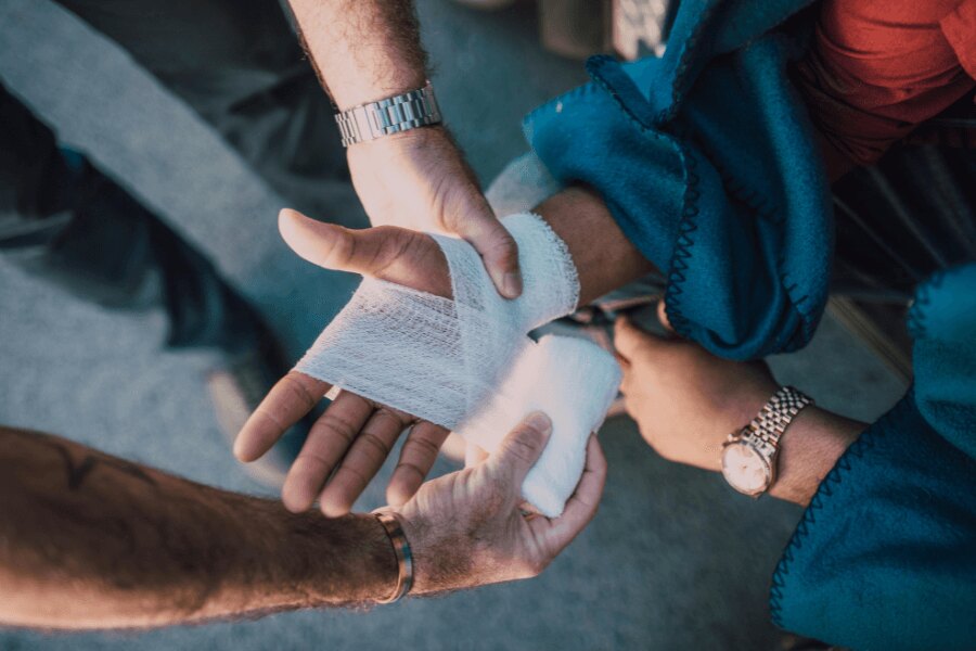 Administering first aid – wrapping an injured wrist with an elastic bandage. Photo: https://www.pexels.com/photo/hands-injury-first-aid-hurt-6519905/