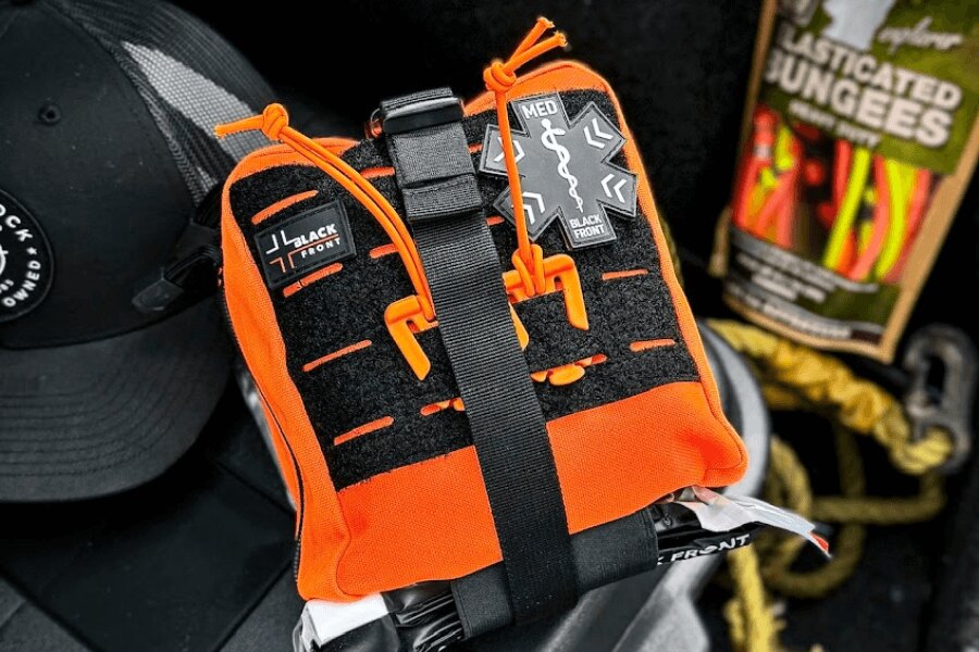Orange IFAK first aid kit with emergency supplies, ready for use in outdoor injury situations. Photo: Rigad.