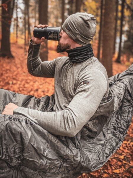 An outdoor professional sitting in a hammock during a rest in the forest, practical use of a hammock for sleeping and relaxation in nature. Photo: Rigad
