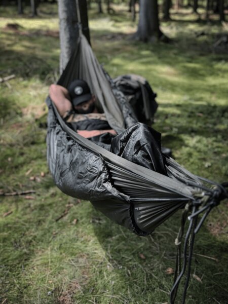 Hammock with an underquilt hung between trees, bottom insulation for comfortable sleep in a cold environment. Photo: Rigad