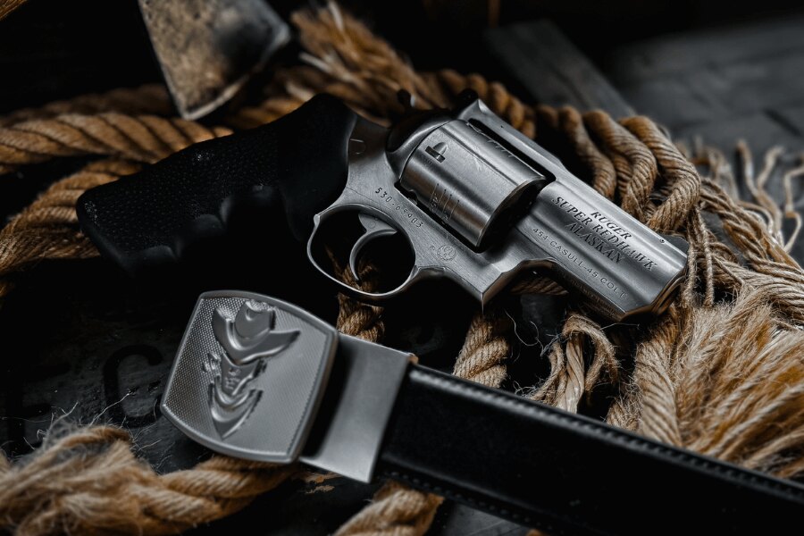 Ruger Super Redhawk Alaskan revolver in .454 Casull resting on a rope beside a leather belt.