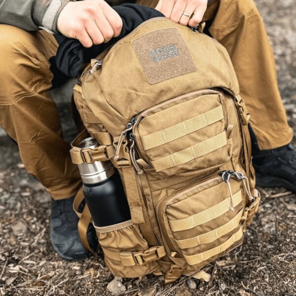 Detail of a Mystery Ranch tactical backpack with a thermos in the side pocket. Photo: Rigad
