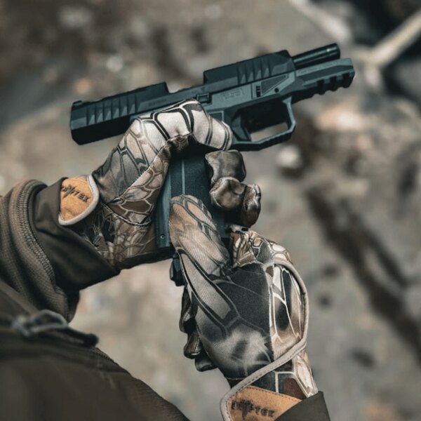 Close-up of gloves featuring Kryptek camouflage pattern while inserting a magazine into a pistol. Photo by Rigad.