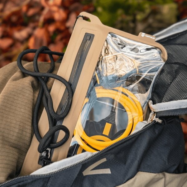 Tactical<sup>&reg;</sup> Splash Pouch 2.0 waterproof case in an open backpack; transparent window holding a phone and cable, lanyard for hanging – a rugged outdoor pouch. Photo: Rigad.