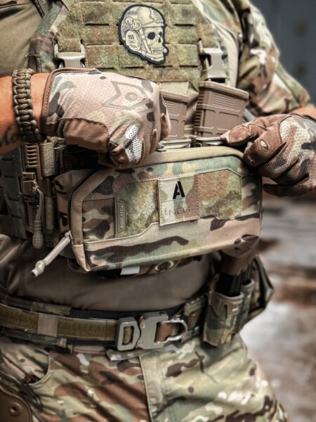 Operator in multicam gear opens the Pincer Admin Panel Agilite<sup>&reg;</sup> attached to the K-ZERO SF plate carrier and handles the magazines. Photo: Rigad