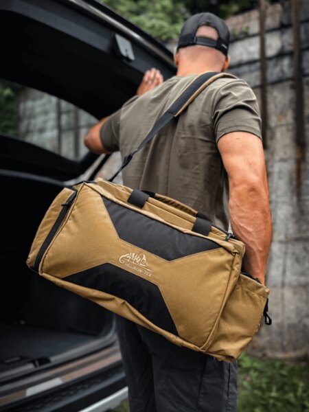 Shooting bag Mission Helikon-Tex® in Coyote color carried over the shoulder in preparation for shooting. Photo: Rigad