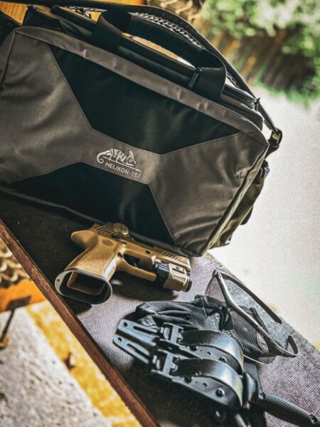 Shooting bag Mission Helikon-Tex<sup>®</sup> placed on the shooting table along with a pistol, glasses, and gear. Photo: Rigad