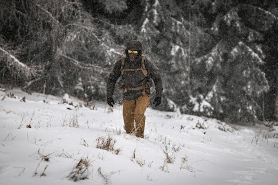 Mountain hiker walking through deep snow in reduced visibility during a winter hike. Photo: Rigad
