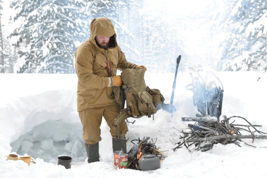 Preparing gear and a warm living space before nightfall during winter camping on snow. Photo: Helikon-Tex, Rigad