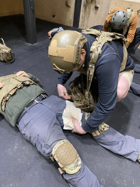 The tactical first aid instructor demonstrates the treatment of a lower limb injury during practical training. Photo: Elite Centers