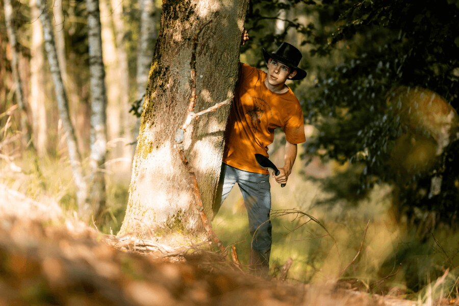 Matěj Houška in the forest with a knife during a bushcraft activity on an outdoor expedition.