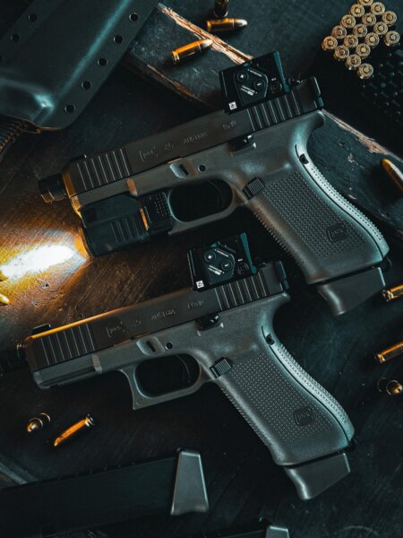 Two Glock 45 Gen6 A-CUT pistols with Aimpoint COA red dot sights on a workbench. Photo: Rigad