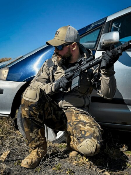 Red Dot One Alpha II tactical pants with knee pads in a shooting position in the field. Photo: Rigad