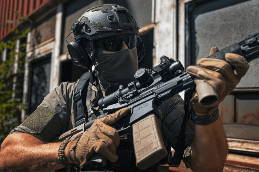 Shooter aiming with an AR-15 equipped with an optic in an outdoor environment, Photo: Rigad