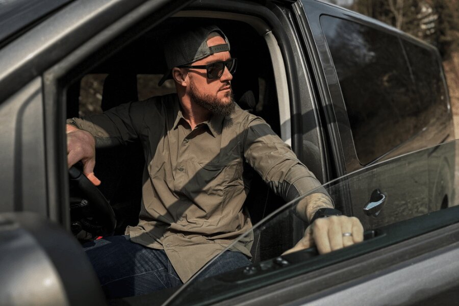 Man Wearing a Vertx<sup>&reg;</sup> Shirt Sitting in a Vehicle and Observing His Surroundings. Photo: Rigad