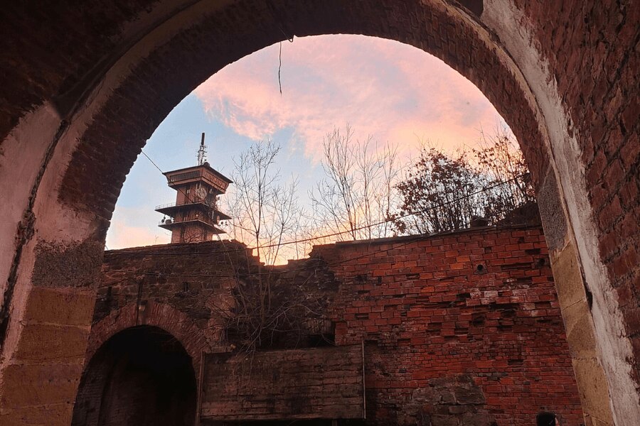 Fort Radíkov near Olomouc, viewed through a brick arch toward the fort complex and observation tower.