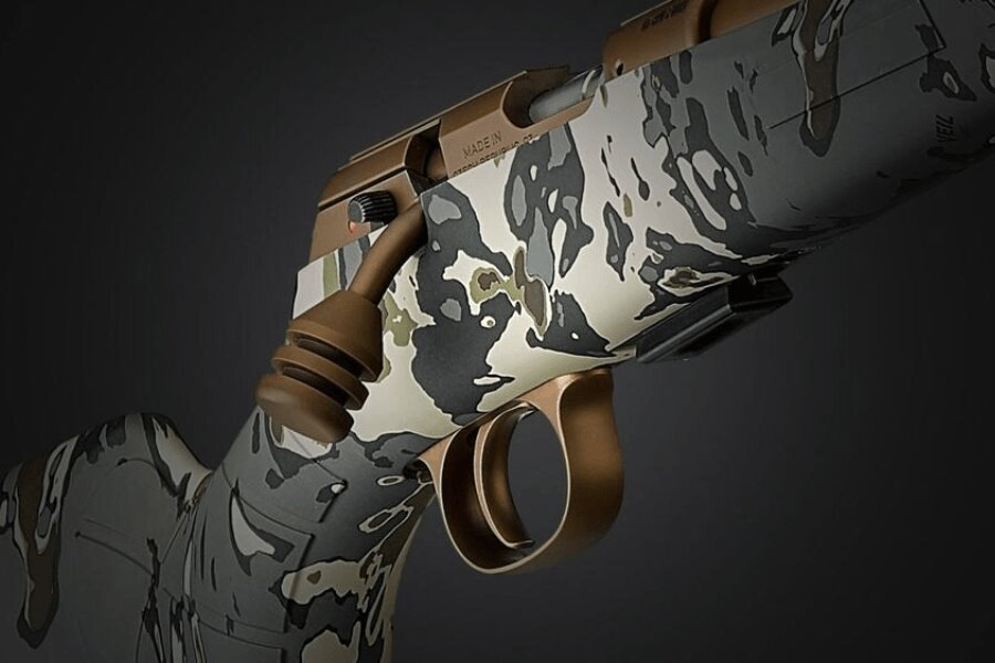 Close-up of the action on a modern bolt-action rimfire rifle with a camouflage stock. Photo: Rigad