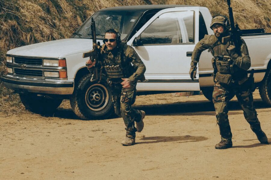A pair of shooters in tactical gear during dynamic rifle training on the range.