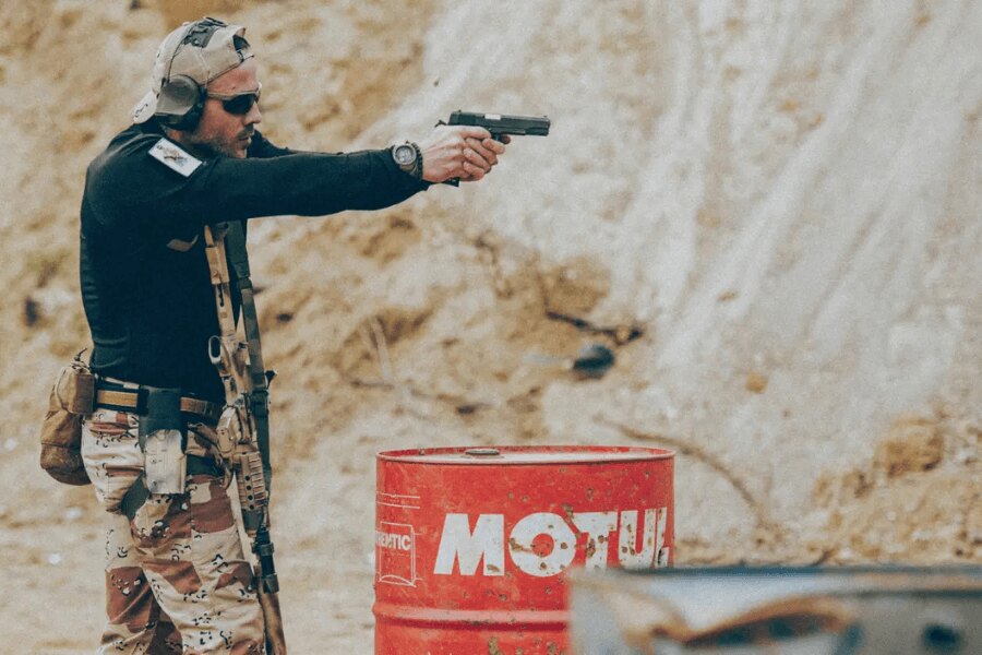 A shooter with a pistol and full gear setup during dynamic range training.