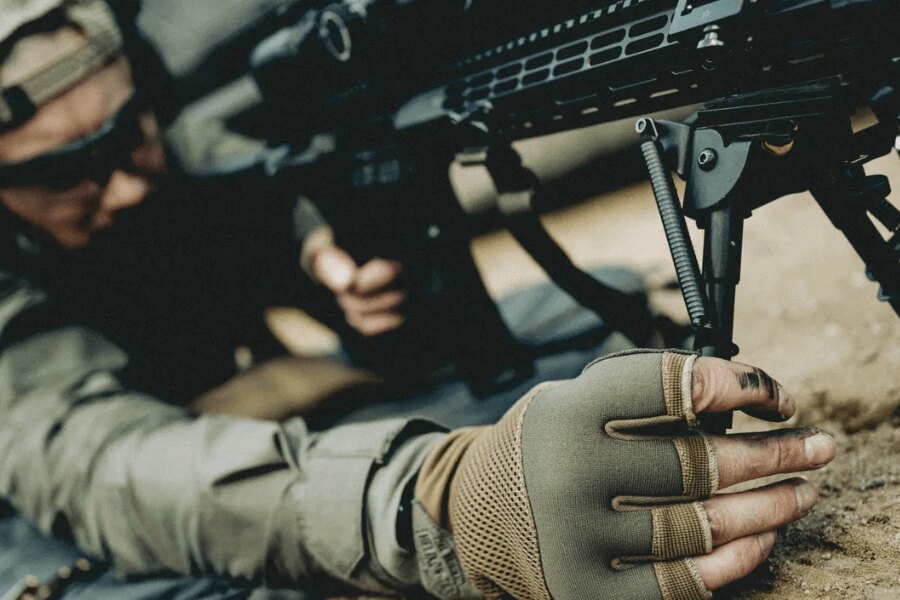 Close-up of rifle stabilization in the prone position using a bipod for improved shooting precision.
