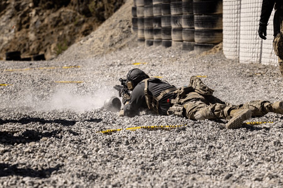 Competitor firing a rifle from the prone position on a gravel surface during a physically demanding stage of Lynx Brutality 2026.