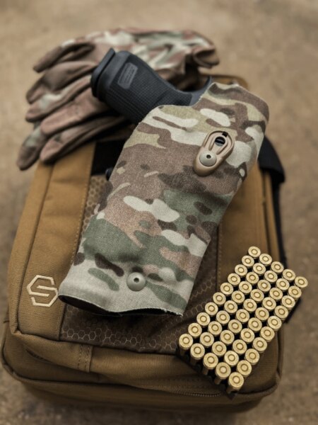9mm Luger cartridges next to a holstered pistol on tactical gear.