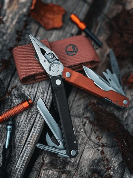 Leatherman Rebar with the pliers deployed and multiple tools extended on a wooden surface.