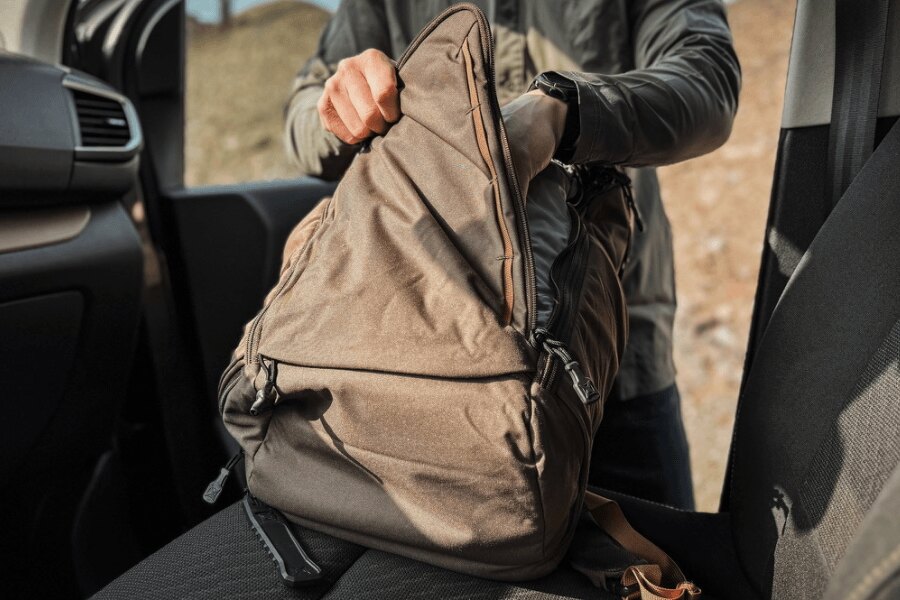 A Vertx Gamut backpack being accessed while resting on a car seat. Photo: Rigad