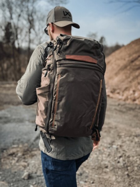 Man carrying a Vertx Gamut backpack while moving through the outdoors. Photo: Rigad