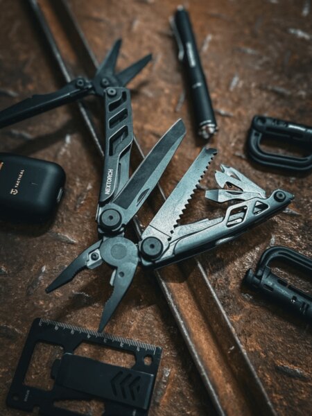 Nextorch multitool with its tools deployed on a metal surface.