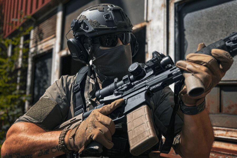 Shooter in tactical gear holding a modern PCC equipped with an optic during firearms training.