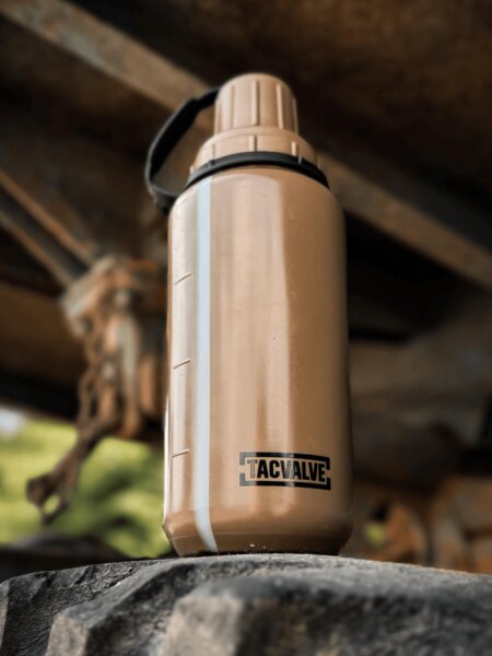 Tan TacValve<sup>&reg;</sup> ModCan military canteen mounted on a military vehicle.