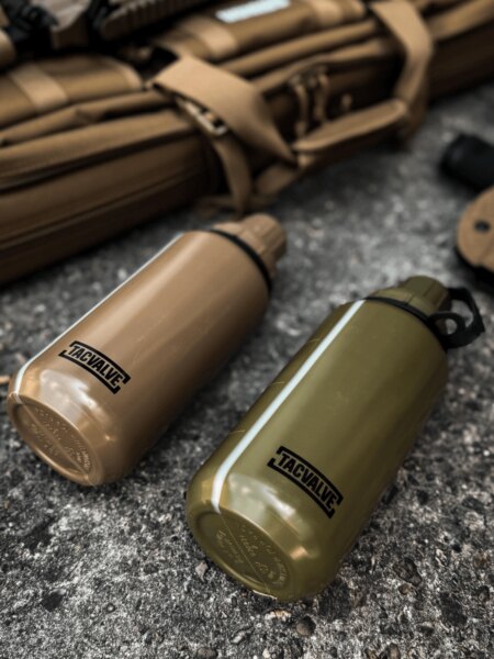 Two TacValve<sup>&reg;</sup> ModCan military canteens in green and tan placed next to shooting equipment.