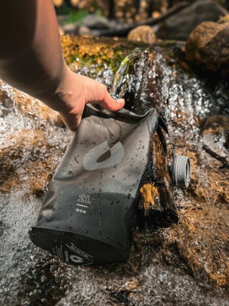Filling a HydraPak soft hydration bladder with water from a mountain stream.