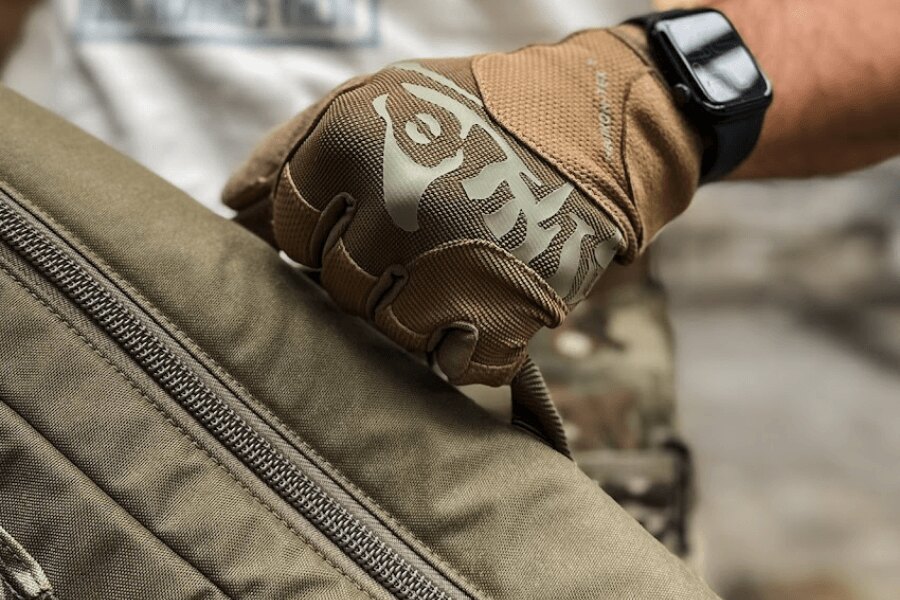 Close-up of a Helikon-Tex® Range tactical glove while handling a range bag.