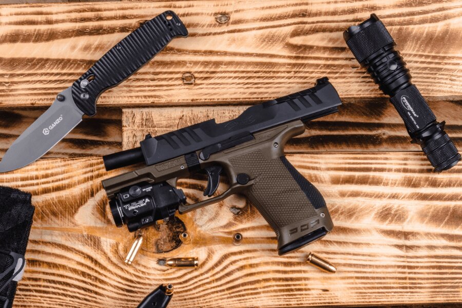 Disassembled Walther PDP Compact pistol with an extended threaded barrel and weapon light.