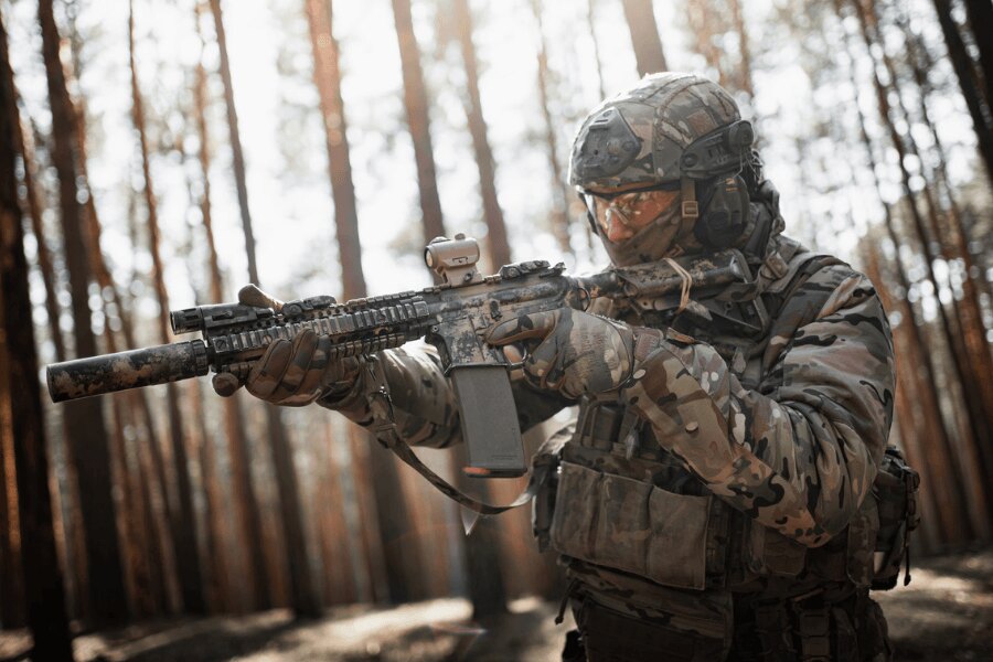 AR-15 rifle with a red dot sight and suppressor during live-fire training in a forest.