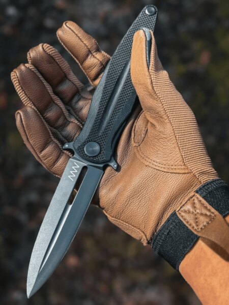 Open ANV folding knife held by a person wearing a tactical glove.