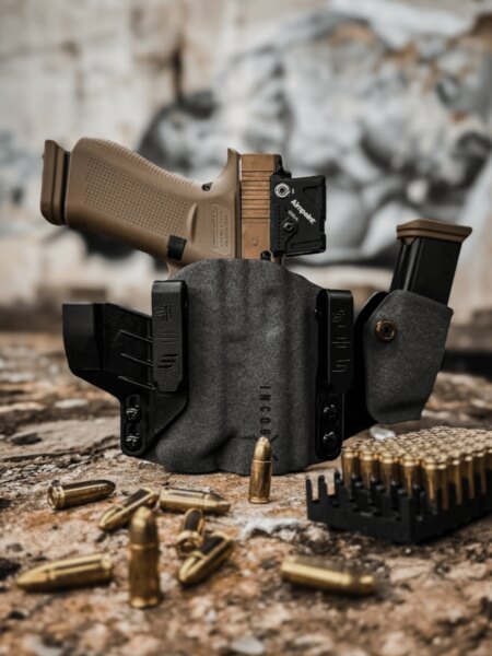 Pistol with an Aimpoint red dot sight secured in a Safariland Incog X holster with a spare magazine.