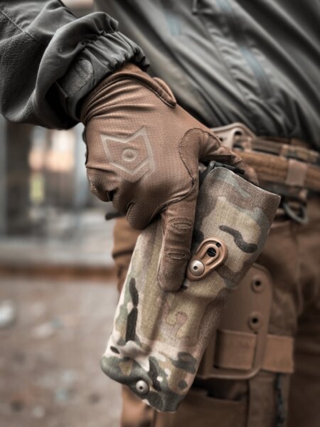 Releasing the retention mechanism on a MultiCam Safariland holster before drawing the pistol.