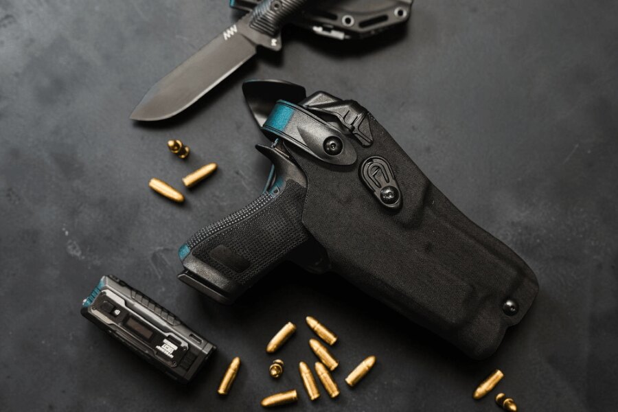 Pistol secured in an active-retention Safariland duty holster with a textile exterior.