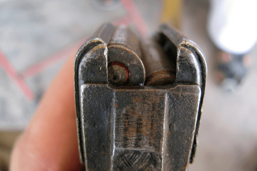 Close-up of the feed lips of a worn steel AK-47 magazine loaded with 7.62×39 mm cartridges.